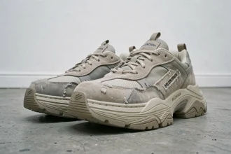 Paire de sneakers chunky style Balenciaga posée sur béton brut dans une galerie minimaliste blanche